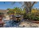 Backyard patio with outdoor dining set, a large tree, and lush landscaping at 809 Royal Dr, Largo, FL 33770