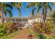 Inviting backyard with a patio, palm trees, and lush landscaping, creating a private and relaxing outdoor space at 809 Royal Dr, Largo, FL 33770