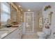 Bathroom featuring single sinks, granite countertops, custom cabinets and a large glass enclosed shower at 809 Royal Dr, Largo, FL 33770