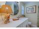 Bathroom featuring single sink with quarts countertops, custom cabinets and a circle mirror at 809 Royal Dr, Largo, FL 33770