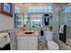 Bright bathroom with a large mirror, modern sink, toilet, glass shower, and unique decorations at 809 Royal Dr, Largo, FL 33770