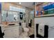 Bathroom features a marble counter, modern sink, toilet, shower, and unique artwork at 809 Royal Dr, Largo, FL 33770