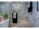 Updated bathroom with a marble tiled shower over bath, modern shower head, and glass shower door at 809 Royal Dr, Largo, FL 33770