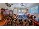 Bright bedroom featuring a large bed with decorative pillows, ceiling fan, and access to outdoor space at 809 Royal Dr, Largo, FL 33770