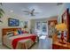 Bright bedroom with a ceiling fan and natural light from the French doors leading to the outside at 809 Royal Dr, Largo, FL 33770