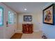 Foyer with white door with windows, antique wooden side table, and artwork on the wall at 809 Royal Dr, Largo, FL 33770