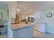 Well-lit kitchen with white cabinets, granite countertops, stainless steel appliances, and modern fixtures at 809 Royal Dr, Largo, FL 33770