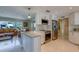 Bright, open-concept kitchen with stainless steel appliances, a center island, and white cabinets at 809 Royal Dr, Largo, FL 33770