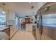 Bright kitchen featuring white cabinets, stainless steel appliances, and granite countertops at 809 Royal Dr, Largo, FL 33770