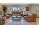 Living room with large windows, leather furniture, and a glass coffee table at 809 Royal Dr, Largo, FL 33770