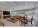 Cozy sun room with tile floors, a beamed ceiling, plenty of windows and a dining area at 809 Royal Dr, Largo, FL 33770
