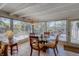 Bright sunroom with large windows overlooking the patio and a cozy dining area at 809 Royal Dr, Largo, FL 33770