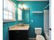 Bright bathroom with blue walls, granite vanity, white toilet, and shower at 8842 Turnstone Haven Pl, Tampa, FL 33619