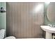 Bathroom with a patterned wallpaper and white pedestal sink at 8842 Turnstone Haven Pl, Tampa, FL 33619