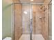 This bathroom features a tiled walk-in shower with glass doors, a showerhead and storage at 8842 Turnstone Haven Pl, Tampa, FL 33619