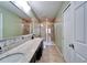 This bathroom has dual sinks with granite countertops, a light green wall color, and a tiled shower at 8842 Turnstone Haven Pl, Tampa, FL 33619