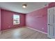 This bedroom has a bright pink wall color, light floors, and a window at 8842 Turnstone Haven Pl, Tampa, FL 33619