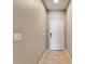 Clean hallway with neutral walls, tile flooring, and a white entry door at 8842 Turnstone Haven Pl, Tampa, FL 33619