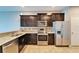 Modern kitchen featuring stainless steel appliances, granite countertops, and dark wood cabinets at 8842 Turnstone Haven Pl, Tampa, FL 33619