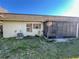 Exterior view of the back of the property featuring an enclosed sunroom and a well-maintained lawn at 9221 Repondo Pl, New Port Richey, FL 34655
