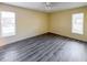 A clean, spacious bedroom with wood-look floors and ample natural light at 9221 Repondo Pl, New Port Richey, FL 34655