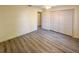 Spacious bedroom with gray wood-look floors, ceiling fan, and closet with louvered doors at 9221 Repondo Pl, New Port Richey, FL 34655