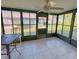 A sun room with large black framed windows, tile floors, and a table with chairs at 9221 Repondo Pl, New Port Richey, FL 34655