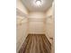 A walk-in closet with wooden floors, shelving, and a central ceiling light at 9221 Repondo Pl, New Port Richey, FL 34655