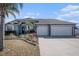 Charming single-story home featuring a three-car garage, a well-manicured lawn, and beautiful landscaping at 9705 Mary Robin Dr, Riverview, FL 33569