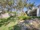 Spacious backyard featuring a lawn, mature trees, privacy wall, and screened porch at 9718 Tiffany Oaks Ln # 12, Tampa, FL 33612