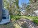 Residential backyard with grassy area, mature trees, and a wooden fence, offering a peaceful outdoor space at 9718 Tiffany Oaks Ln # 12, Tampa, FL 33612