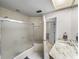 Well-lit bathroom with walk-in shower, white cabinets, granite countertop, and modern fixtures at 9718 Tiffany Oaks Ln # 12, Tampa, FL 33612