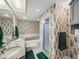 Well-lit bathroom featuring double sinks, floral wallpaper, and a shower stall at 9718 Tiffany Oaks Ln # 12, Tampa, FL 33612