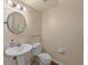 Half bathroom with a pedestal sink, toilet, and decorative mirror, offering a convenient and stylish space at 9718 Tiffany Oaks Ln # 12, Tampa, FL 33612