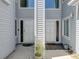Front entrances with light gray siding and matching doors, separated by a white column at 9718 Tiffany Oaks Ln # 12, Tampa, FL 33612