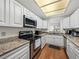 Bright kitchen featuring granite countertops, stainless steel appliances, and hardwood floors at 9718 Tiffany Oaks Ln # 12, Tampa, FL 33612