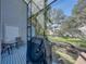 Outdoor patio with screened enclosure, table and chairs, and a grill covered with a black cover at 9718 Tiffany Oaks Ln # 12, Tampa, FL 33612