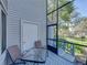 Screened-in patio with table and chairs, offering a view of the green yard and surrounding landscape at 9718 Tiffany Oaks Ln # 12, Tampa, FL 33612