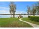 Lush green lawn leading to a private covered boat dock on the water under a clear sky at 9902 Menander Wood Ct, Odessa, FL 33556