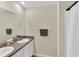 Bathroom featuring double sinks, granite countertop, and shower with decorative curtain at 10864 Penny Gale Loop, San Antonio, FL 33576