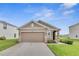 Single-story home with well-maintained lawn, neutral exterior, and an attached two-car garage at 10864 Penny Gale Loop, San Antonio, FL 33576