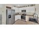 Modern kitchen featuring white cabinets, granite countertops, and stainless steel appliances at 10864 Penny Gale Loop, San Antonio, FL 33576