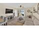 Comfortable living room featuring a sectional sofa, entertainment center, and access to outdoor area at 10864 Penny Gale Loop, San Antonio, FL 33576