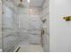 Luxurious bathroom showcases a glass-enclosed shower with marble tiling and elegant gold fixtures at 1100 Webb Dr, Clearwater, FL 33755