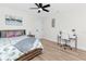 A cozy bedroom featuring beachy decor, light wood flooring, and a modern ceiling fan at 1100 Webb Dr, Clearwater, FL 33755