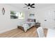 Bright bedroom with wood-look floors, ceiling fan, and a sunny window at 1100 Webb Dr, Clearwater, FL 33755