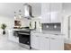 Bright kitchen featuring white cabinetry, stainless steel appliances, marble countertops, and pendant lighting at 1100 Webb Dr, Clearwater, FL 33755