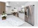 Modern kitchen features stainless steel appliances, white cabinets, and marble countertops with barstool seating at 1100 Webb Dr, Clearwater, FL 33755