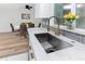 Bright kitchen sink area features gray backsplash, stainless steel sink, and yellow flowers near window at 1100 Webb Dr, Clearwater, FL 33755