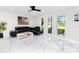 Bright living area featuring marble floors, a black leather couch, a ceiling fan, and natural light at 1100 Webb Dr, Clearwater, FL 33755